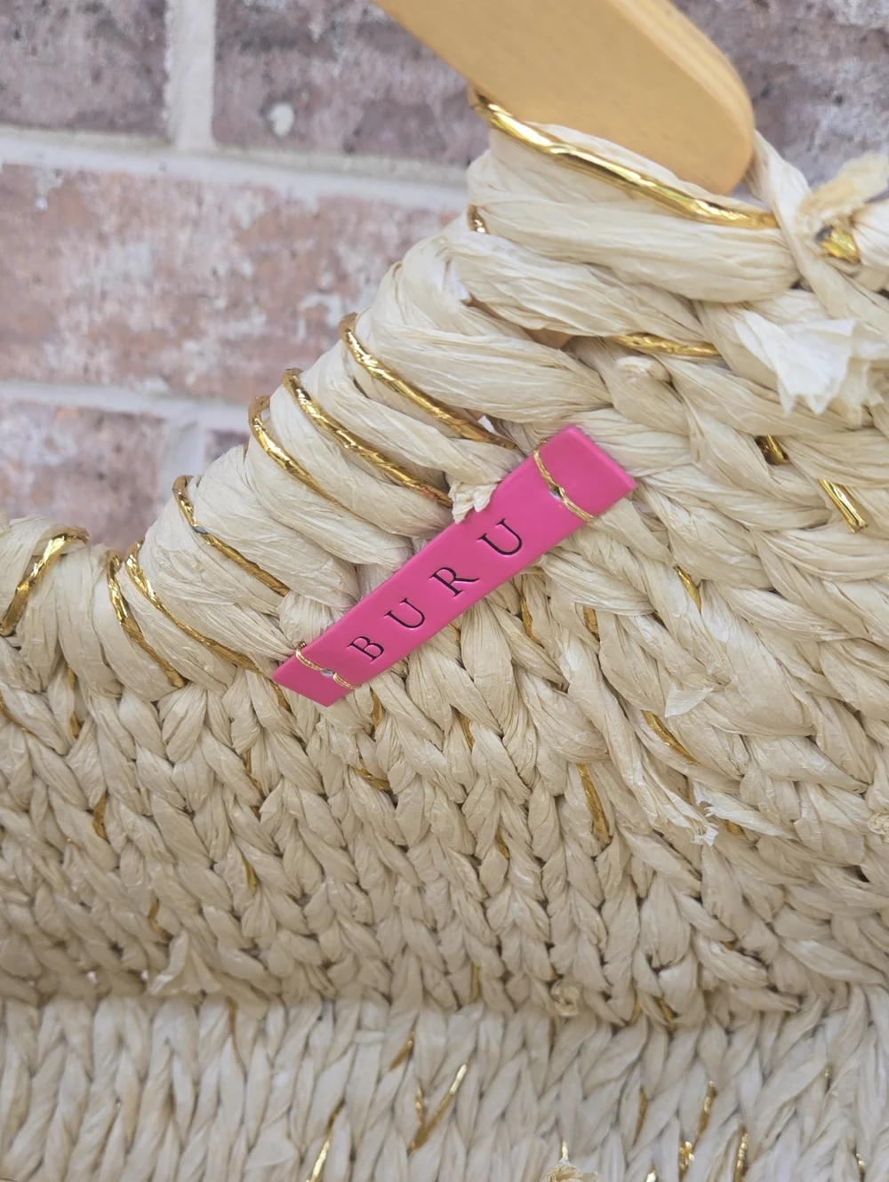 Buru Shop woven crescent straw satchel with structured geometric handles.